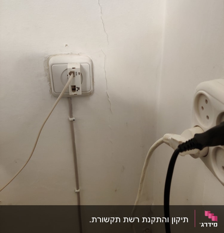 שקע רשת עם כבל מחובר לקיר לבן